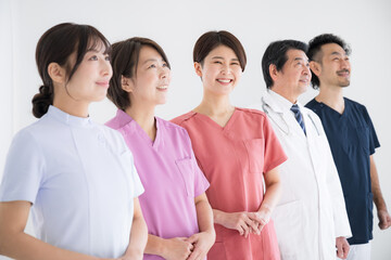 Doctors and nurses enjoying a successful career change. Only nurses smile and look at the camera.	