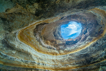 A heart-shaped skylight illuminates the interior of Benagil Cave, one of the most stunning sea caves in the world. Algarve, Portugal.