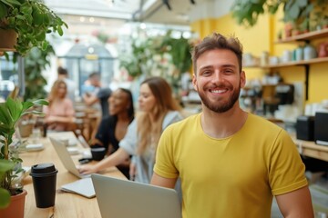 Freelancer smiling in a coworking space holding a laptop with business people working in the background