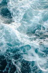 Fototapeta premium The image is of a large body of water with waves crashing against the shore. The water is a deep blue color, and the waves are high and powerful. Scene is one of strength and power
