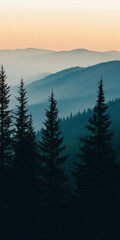 A tranquil scene of pine trees silhouetted against misty, layered mountains at dawn, capturing the peaceful essence of nature.