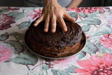 Man's hand and delicious chocolate cake