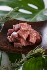 raw pork pieces chopped in cube on a wooden plate