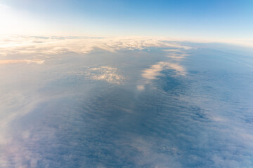 Beautiful orange and pink sunrise over the clouds, view from the plane.