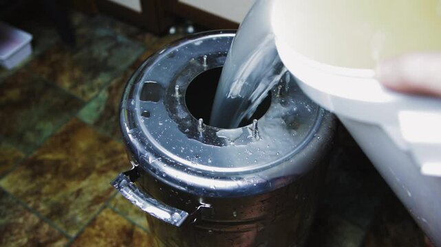 Distillation of braga into moonshine. Pouring into a moonshine distiller.
