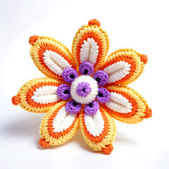 A knitted soft toy in the form of a beautiful blooming flower, made of woolen threads in orange and white tones with purple inserts. White background.