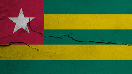 Togo flag on cracked wall background, flag with crack line