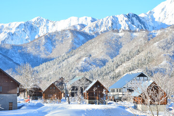 新雪に輝く銀山平のログハウス群と越後三山 © tqmnk924