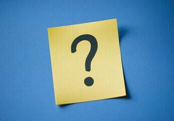 Yellow sticky note with a black question mark on a blue background, close-up.