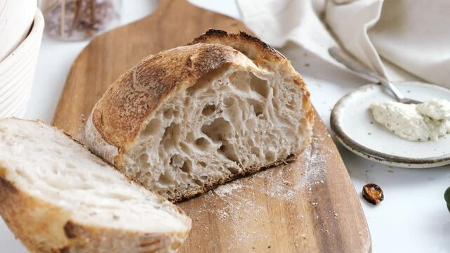 Artisan Batard Sourdough healthy Bread with leaf scoring. Open crumb high hydration Sourdough bread set on white table.