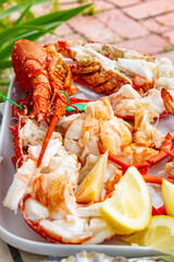 boiled rock lobster crayfish served with lemon wedges on a platter