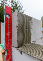 A red level is being used to measure a wall