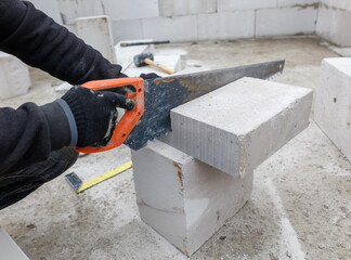 A man is cutting a block of concrete with a saw