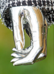 A silver hand is holding another silver hand