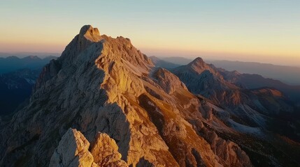 Obraz premium Majestic mountain peak at sunset, aerial view.
