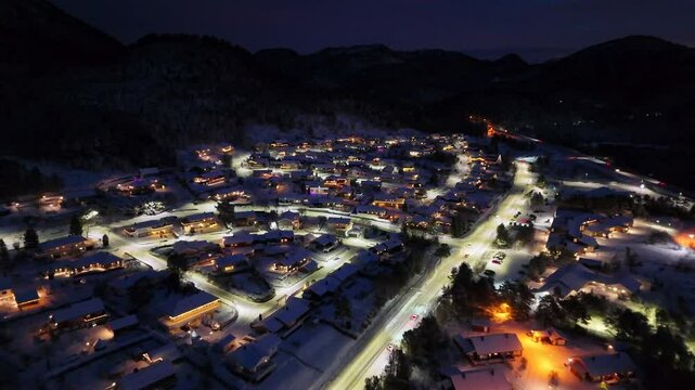 view of the illuminated snow-covered residential area of Storbakken at night on the island of Frei