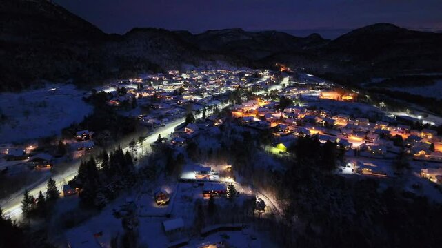 view of the illuminated snow-covered residential area of Storbakken at night on the island of Frei