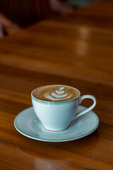 A cup of coffee latte with froth art on the table