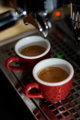 Two red cups on espresso machine