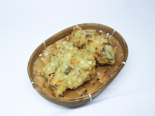 Bakwan, Bala-Bala or Vegetable Fritters, traditional Indonesian snack served in bamboo basket and Isolated against white background.