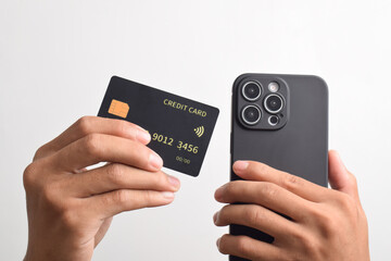 Male hands holding mobile phone and black credit card isolated on white background. Mobile payment ,Online shopping concept