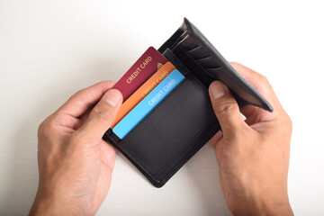 Hand taking out credit card from wallet isolated on white background