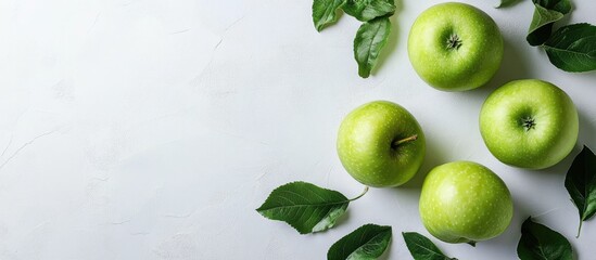 Obraz premium Fresh Green Apples with Leaves on White Background Ideal for Healthy Lifestyle and Culinary Promotion with Space for Text