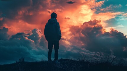Obraz premium Solitude Under a Fiery Sky: A Contemplative Silhouette Against a Dramatic Sunset