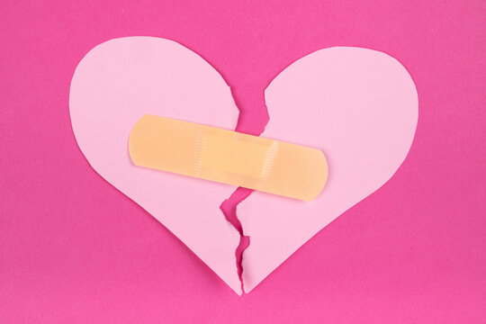 Torn paper pink heart with beige adhesive bandage. Healed broken heart concept - Powered by Adobe