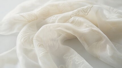 Cream-colored fabric with subtle embossed floral pattern, softly draped on a white background.