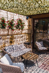 Outdoor cafe in Montenegro on the embankment, bright sun, heat, table and chairs. Hard shadows under the camouflage net