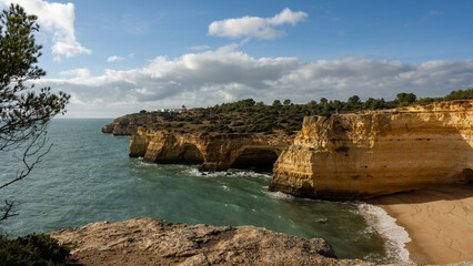 Stunning Coastal Cliffs of Algarve, Portugal with Dramatic Rock Formations, Natural Arches, and Sandy Beach Under Blue Sky, Rugged Coastline and Serene Landscape for Nature Enthusiasts
