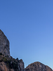 Naklejka premium Vertical image of rocky mountain on a blue sky in the background with copy space