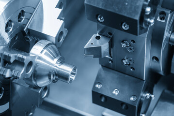 The CNC lathe machine forming  cutting the metal shaft parts in the light blue scene.