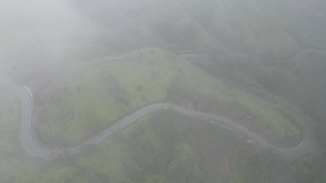 Aerial view of a mountain road at Alto de la Virgen between Constanza and La Vega in the central range of the Dominican Republic on a misty day