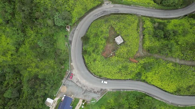 Aerial view of a car driving on the mountain road passing the viewpoint Alto de la Virgen between Constanza and La Vega in the lush central range of the Dominican Republic