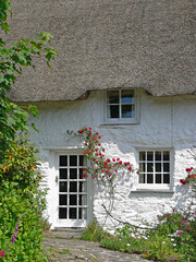 pictorial cottage with straw thatched roof, facade with roses © SusaZoom