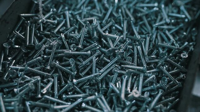 Bunch of galvanized stainless screws with flat countersunk head, hardware background.