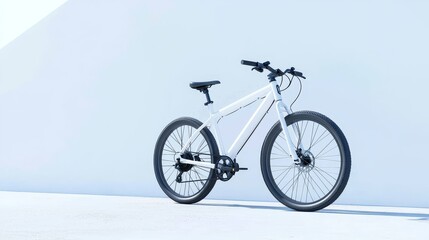 Naklejka premium In a minimalist urban setting with a cobblestone street, a modern electric bicycle with a sleek silver frame and black accents leans against a pure white wall, creating a clean and industrial-chic