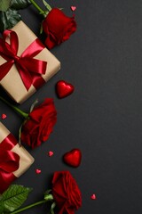 Beautiful red roses, gift boxes and hearts on black background