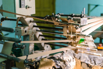 Glue machine for paper tube cores, steel metal engine, technology manufacturer in operation process in industry manufacturing plant factory. Raw product equipment. Cardboard cargo in warehouse