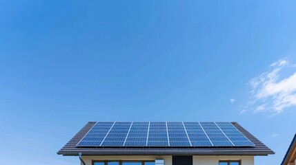 Naklejka premium Solar panels on house roof against blue sky.