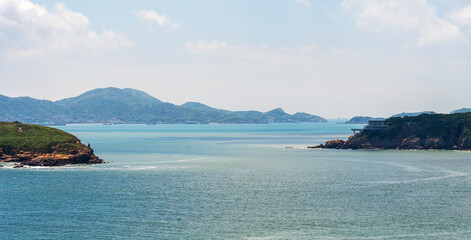 Fototapeta premium Tranquil Coastal Landscape with Distant Islands and Clear Blue Sky