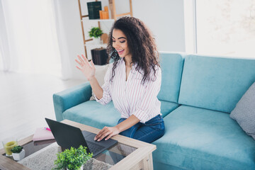 Photo of nice young girl wave hi speak video call laptop wear striped shirt white interior apartment indoors