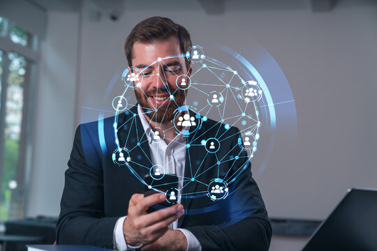 Smiling businessman talking holding using smartphone typing at office workplace with notebook. Concept of distant work, business education. Social network and media net.
