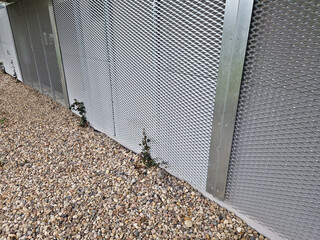 perforated metal sheet in the basement of the house in lining. trellis for climbing plants. the...