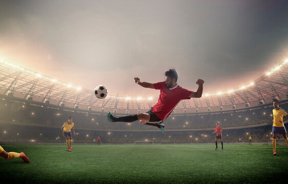 Football player kicking in front of floodlights