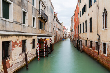 Venetian Canal with Colorful Striped Posts and Bridge
