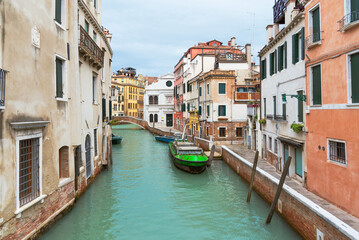 Obraz premium Canal in Venice with Boats and Bridge