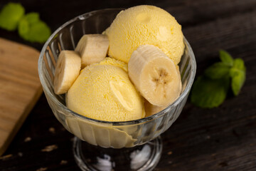 creamy ice cream with yellow banana slices in a glass cup